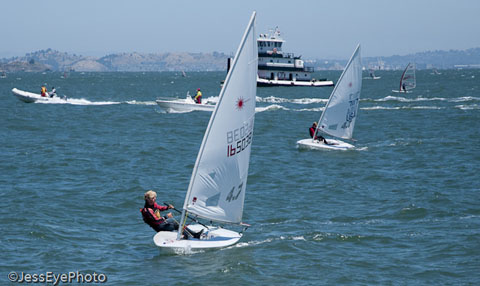 Laser 4.7 racing with tugboat in background